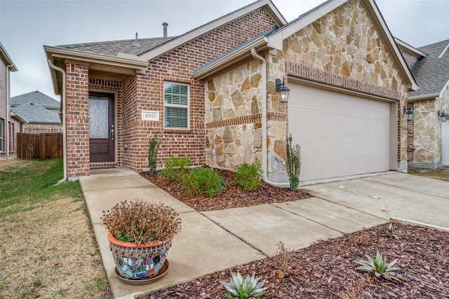 view of front of home featuring concrete driveway, a garage, stone siding, and roof with shingles