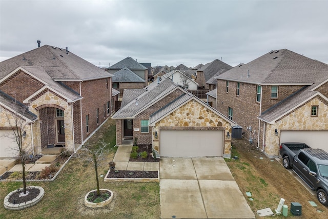 view of property with central AC unit, a garage, and a front lawn