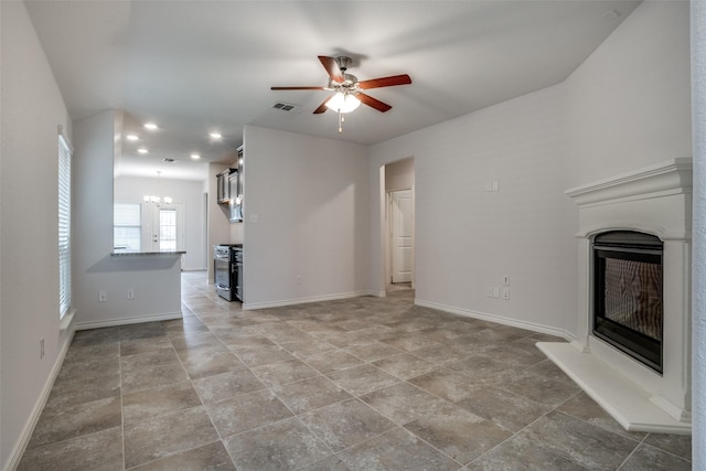 unfurnished living room with ceiling fan with notable chandelier