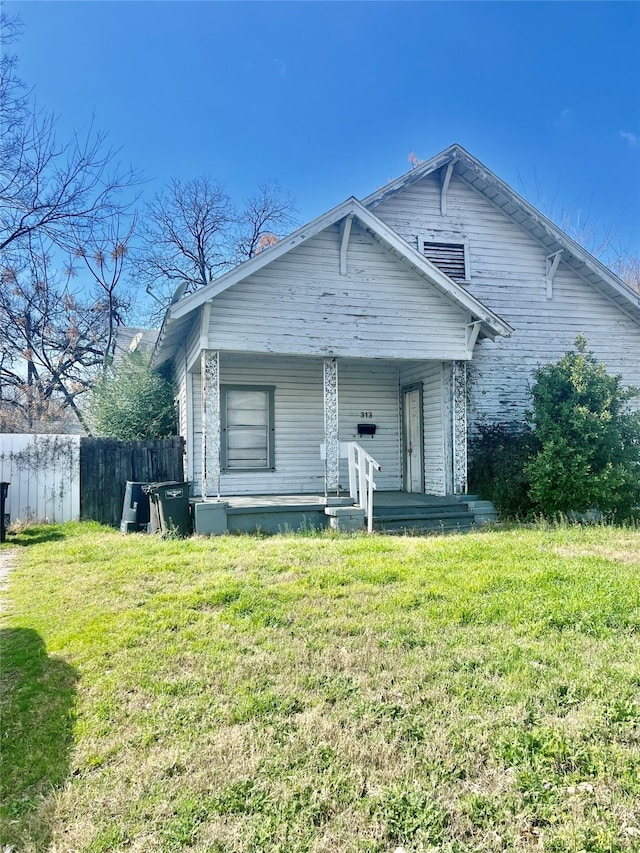 bungalow-style home with covered porch and a front lawn