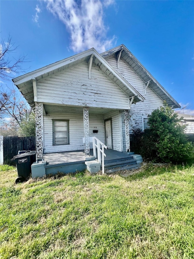 bungalow-style home with covered porch and a front lawn