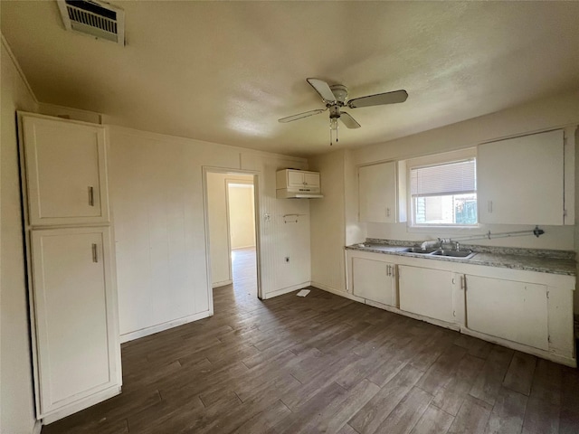 kitchen with sink, ceiling fan, dark hardwood / wood-style floors, white cabinets, and an AC wall unit