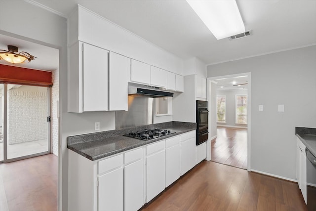 kitchen with visible vents, white cabinets, dark wood-style floors, oven, and under cabinet range hood