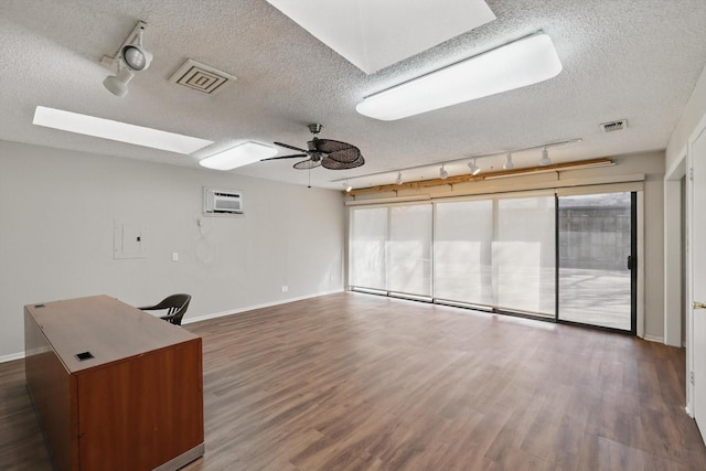 interior space featuring a skylight, visible vents, ceiling fan, and wood finished floors