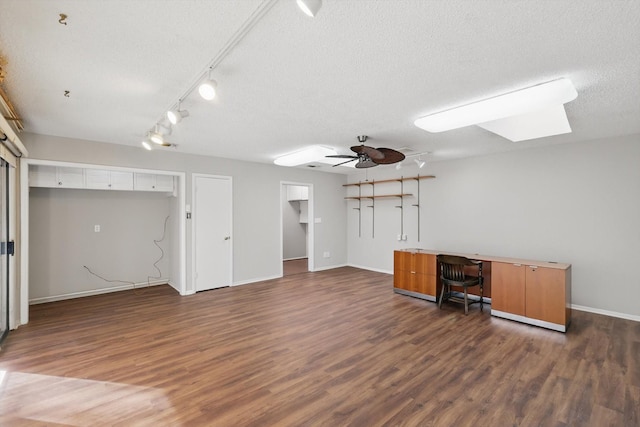 unfurnished office featuring a ceiling fan, a textured ceiling, baseboards, and wood finished floors