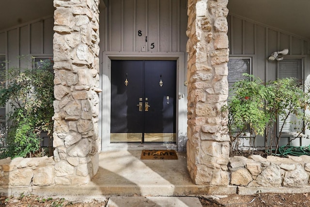 doorway to property with stone siding and board and batten siding