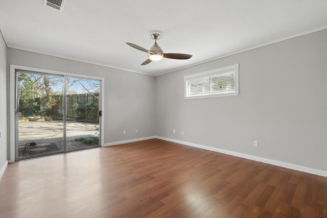 spare room with a wealth of natural light, visible vents, and wood finished floors