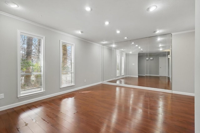 empty room featuring ornamental molding, wood-type flooring, and plenty of natural light