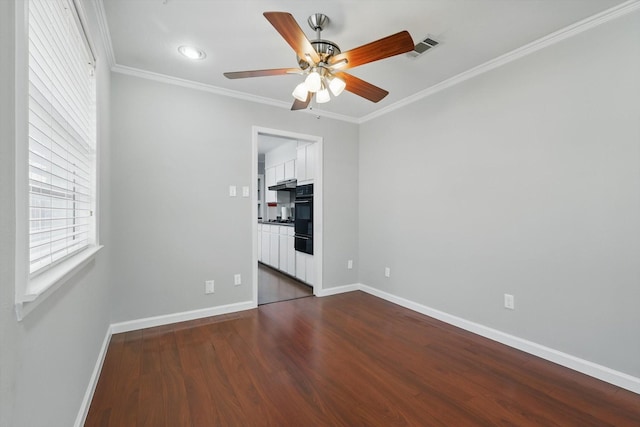 unfurnished bedroom with baseboards, visible vents, dark wood-style floors, ceiling fan, and crown molding