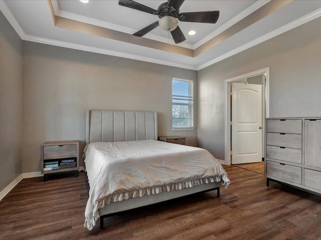 bedroom with dark wood-type flooring, crown molding, and a raised ceiling