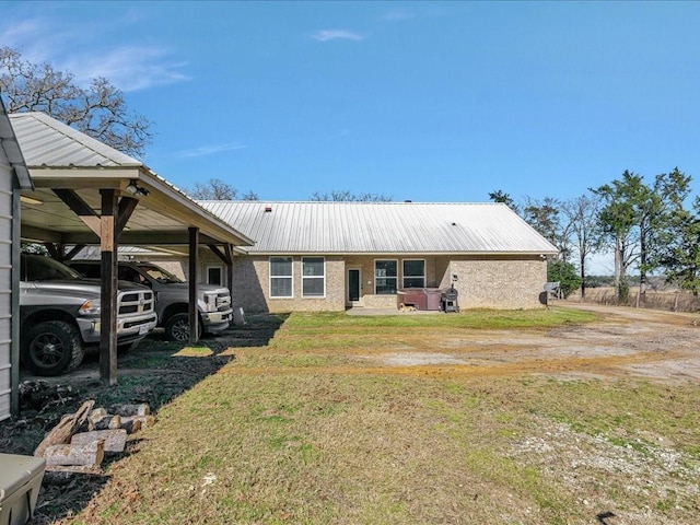 rear view of house with a lawn and a carport