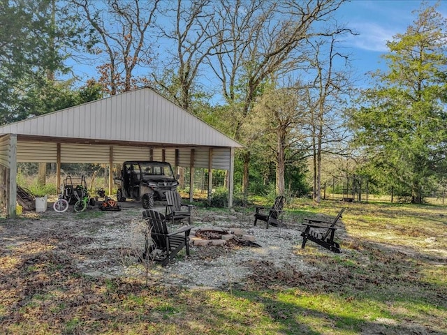 exterior space featuring a carport and an outdoor fire pit