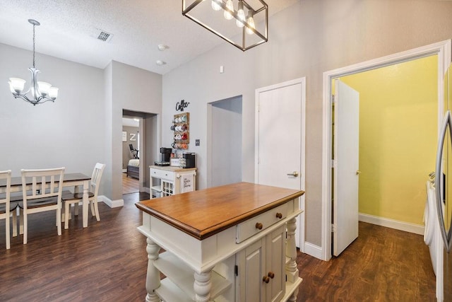 kitchen with a kitchen island, dark hardwood / wood-style floors, hanging light fixtures, and a notable chandelier