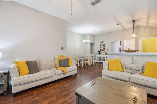 living room featuring dark hardwood / wood-style floors, vaulted ceiling, and a notable chandelier