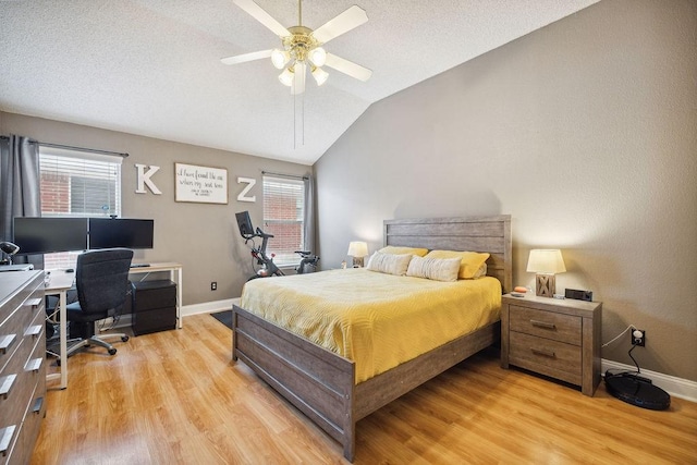 bedroom with ceiling fan, lofted ceiling, a textured ceiling, and light wood-type flooring