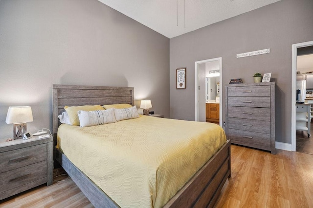 bedroom featuring ensuite bathroom and light hardwood / wood-style floors