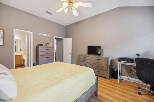 bedroom with vaulted ceiling, wood-type flooring, ensuite bathroom, and ceiling fan