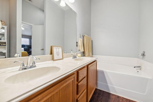 bathroom featuring vanity, hardwood / wood-style floors, and a washtub