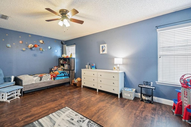 bedroom with ceiling fan, dark hardwood / wood-style floors, and a textured ceiling