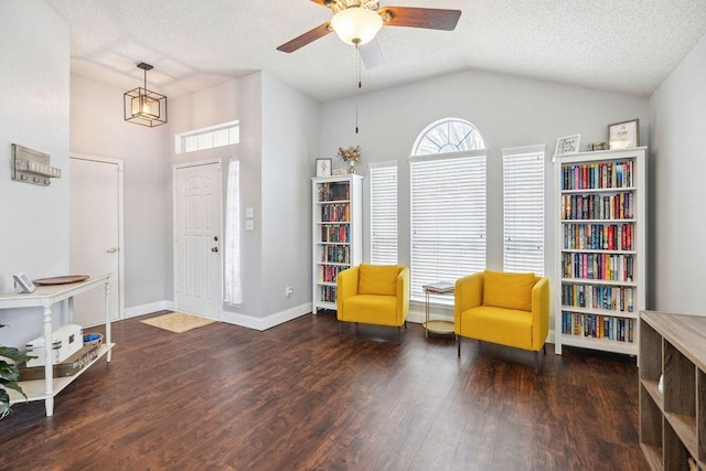 living area featuring dark wood-type flooring, ceiling fan, lofted ceiling, and a textured ceiling