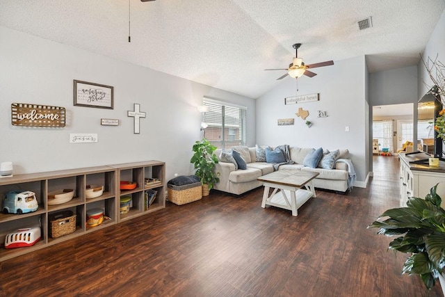 living room featuring dark wood-type flooring, vaulted ceiling, a textured ceiling, and ceiling fan