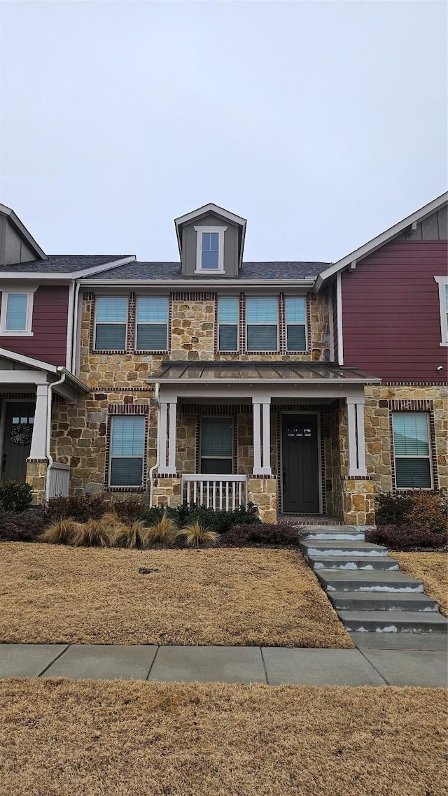 view of front of home with covered porch and stone siding