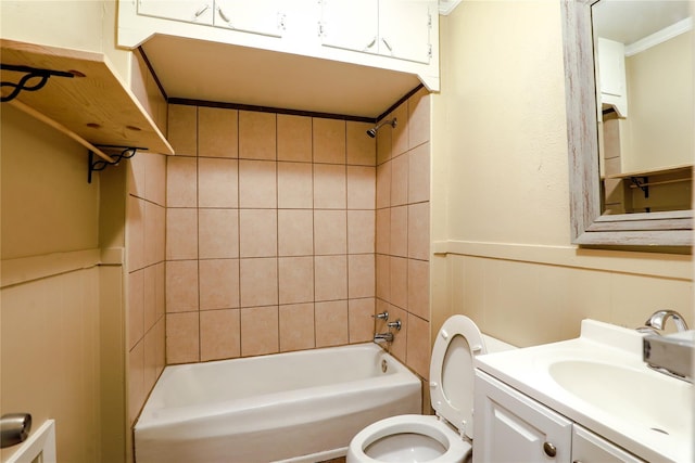 full bathroom featuring vanity, tiled shower / bath combo, ornamental molding, and toilet