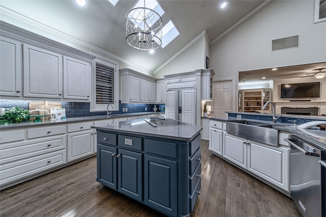 kitchen with sink, dishwasher, a kitchen island, black electric cooktop, and decorative light fixtures