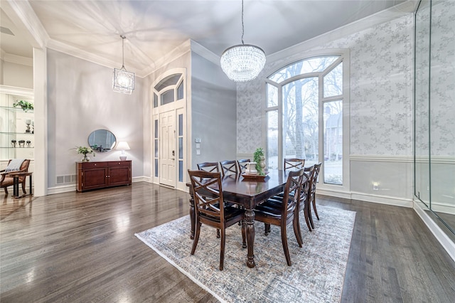 dining area featuring crown molding, an inviting chandelier, and dark hardwood / wood-style flooring