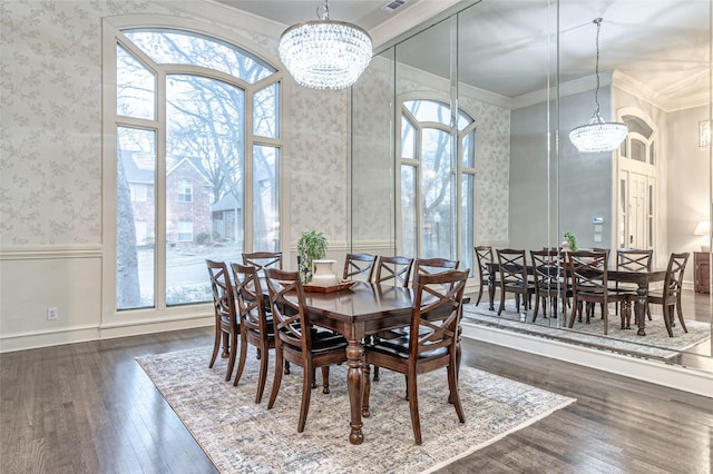 dining area featuring a towering ceiling, dark wood-type flooring, ornamental molding, and a chandelier