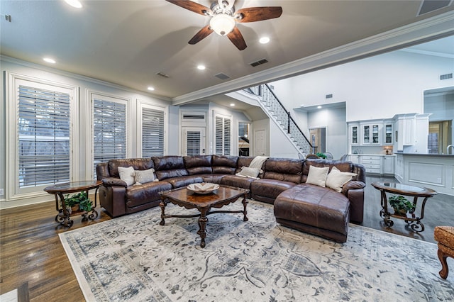 living room with dark hardwood / wood-style flooring, crown molding, and ceiling fan