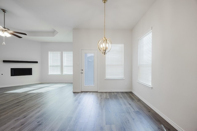 unfurnished living room featuring dark wood-type flooring and ceiling fan with notable chandelier