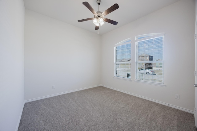 carpeted spare room featuring ceiling fan