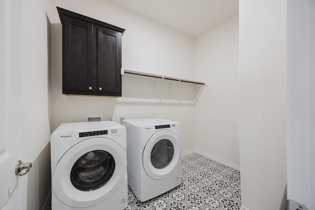 laundry area featuring cabinets, light tile patterned floors, and washing machine and clothes dryer