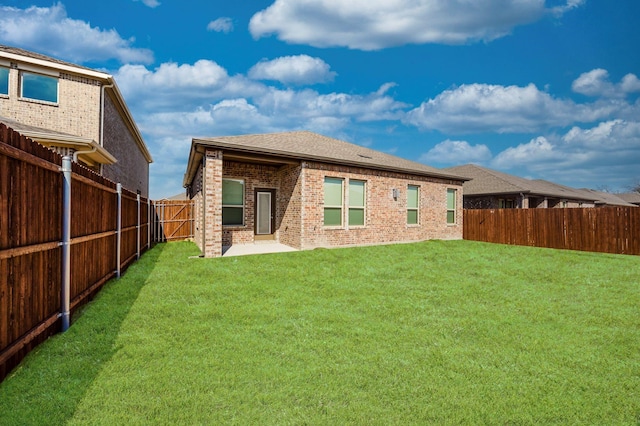 back of house featuring a patio and a yard