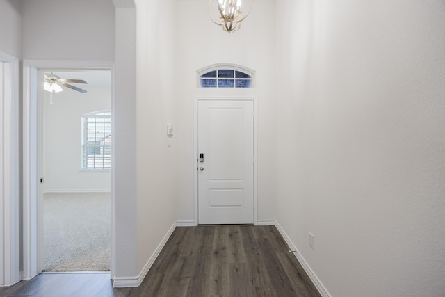 entryway with ceiling fan with notable chandelier and dark hardwood / wood-style flooring