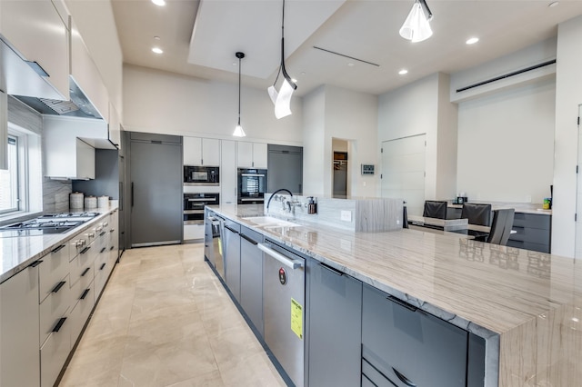 kitchen featuring pendant lighting, gray cabinets, and a large island with sink