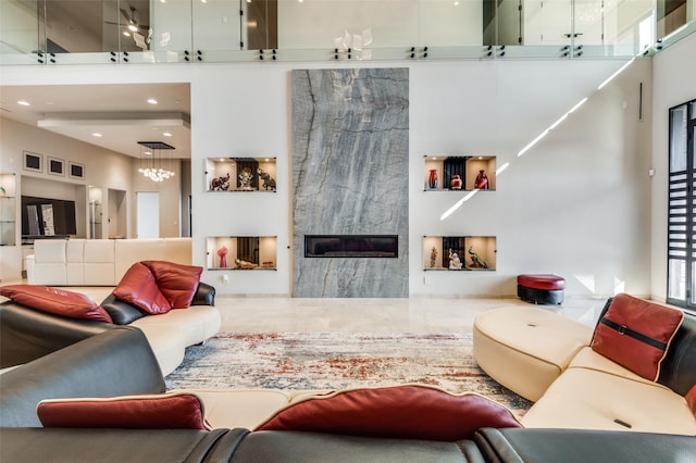 living room with a premium fireplace and a high ceiling