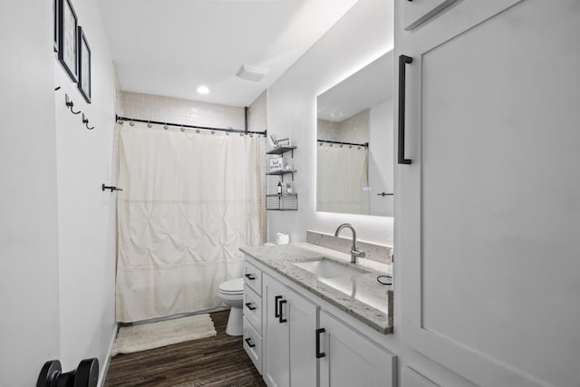 bathroom featuring toilet, vanity, and hardwood / wood-style floors