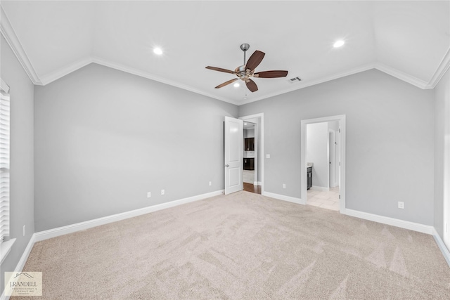 unfurnished bedroom featuring ornamental molding, vaulted ceiling, and light colored carpet