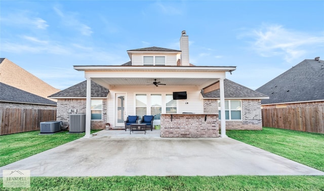 rear view of house with cooling unit, a lawn, ceiling fan, and a patio area