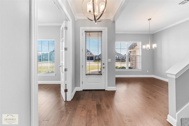 foyer featuring crown molding, a healthy amount of sunlight, hardwood / wood-style floors, and a notable chandelier