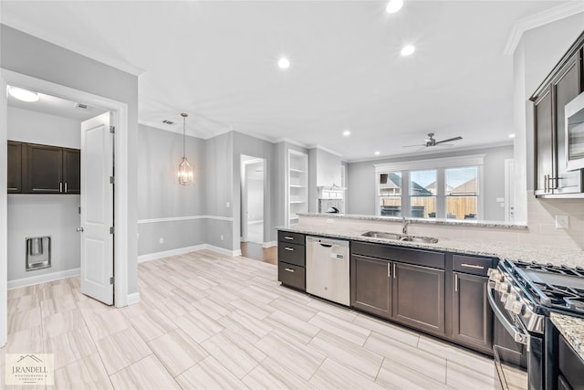 kitchen featuring light stone counters, stainless steel appliances, sink, and pendant lighting