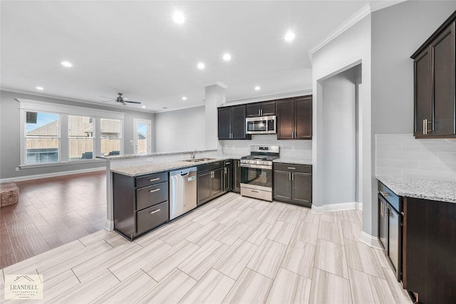 kitchen featuring appliances with stainless steel finishes, sink, light stone counters, and kitchen peninsula