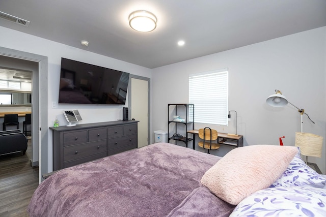 bedroom featuring multiple windows and dark hardwood / wood-style flooring