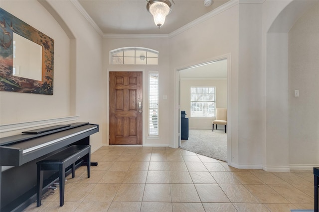 entryway featuring arched walkways, ornamental molding, light tile patterned flooring, and baseboards