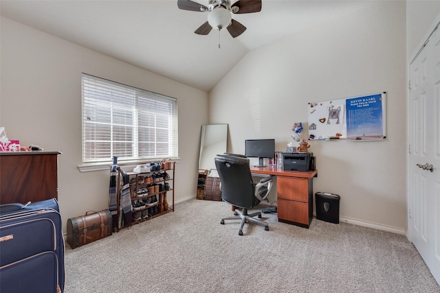 carpeted office space featuring lofted ceiling, baseboards, and a ceiling fan