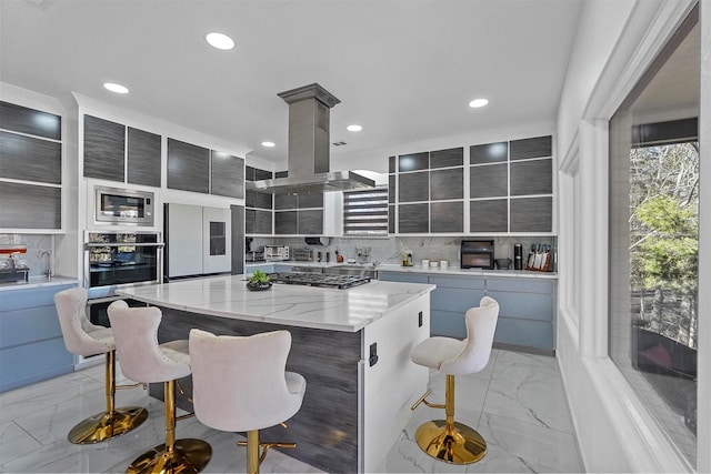 kitchen with a kitchen bar, decorative backsplash, island exhaust hood, a center island, and built in appliances