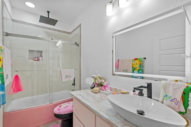 full bathroom featuring vanity, shower / bath combination with glass door, and toilet