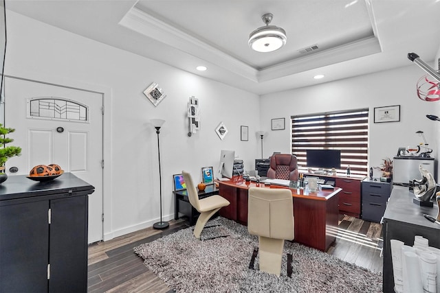 office area featuring a raised ceiling, ornamental molding, and dark hardwood / wood-style flooring